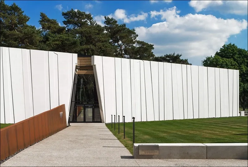 Le second axe, axe de l’histoire, est symbolisé par une lame en acier corten qui guide le visiteur vers l’entrée.