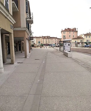 La rue du 4-Septembre (ici côté sud) a vu la superficie de ses trottoirs – en béton bouchardé – tripler en superficie. En médaillon : le béton – un C25/30 classé XF2 à base de ciment Vicat CEMI 52,5 – intégrant du Comblanchien, de calibre 20/40 et 16/22. 