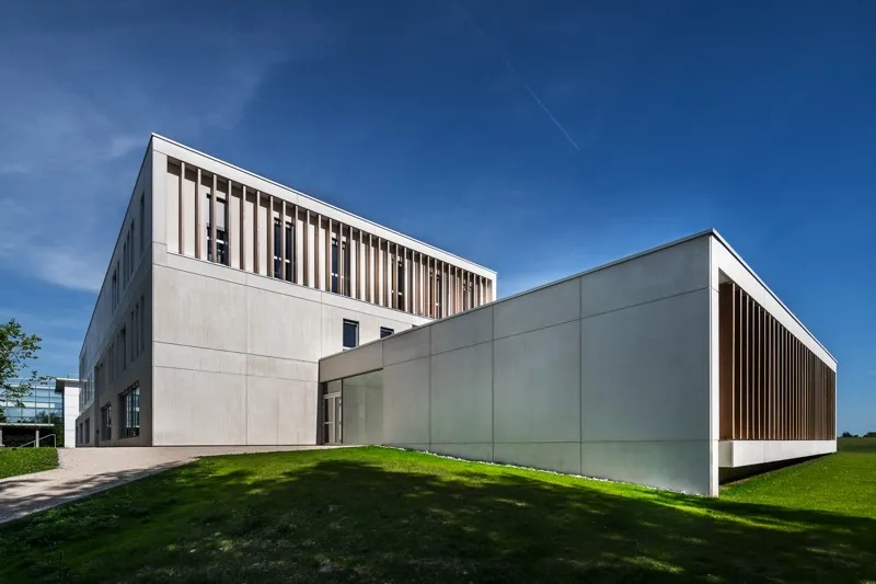 L’ensemble de l’enveloppe du bâtiment est réalisé avec des éléments préfabriqués en béton de type mur à co rage et isolation intégrés au parement lisse ou texturé et dont la couleur beige rappelle la tonalité de la pierre locale.