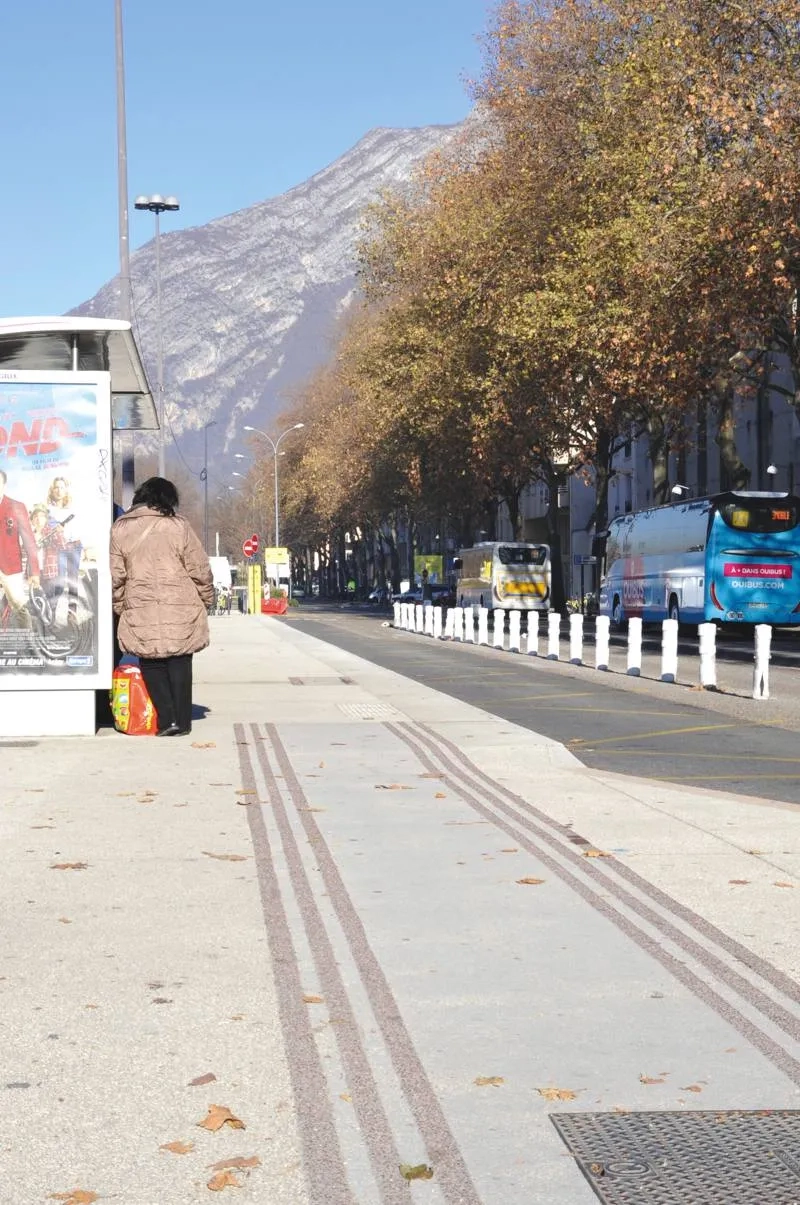 Des bandes rugueuses de couleur grenat, créées sur le béton désactivé, signalent la présence de voies cyclables.