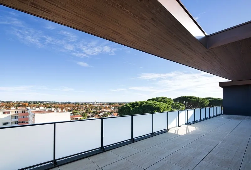 Vue panoramique depuis une terrasse du dernier étage, cadrée par la toiture de l’attique.