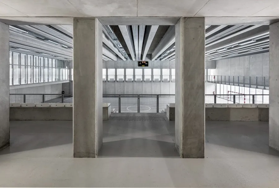 La monochromie du béton est apaisante et pérenne. Les tribunes surplombent la salle et ont une capacité de 160 places assises.