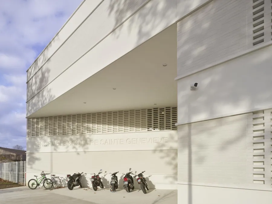 À l’angle, un mur, sur lequel est imprimé en creux le nom de l’établissement, conduit vers l’entrée du collège et du lycée. @ Roland Halbe