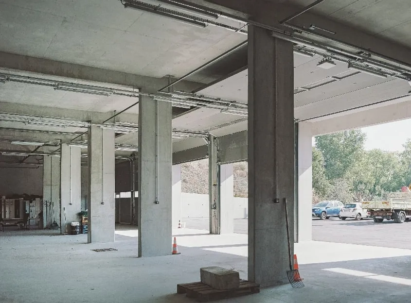 Vue sur le garage des véhicules d’intervention et des engins routiers ouvert sur la cour.