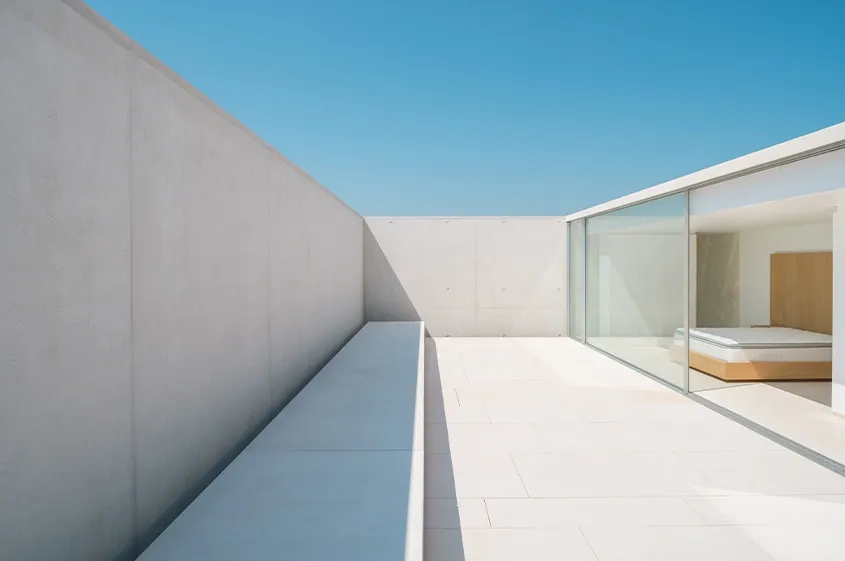 Villa SI – Vue d’une chambre d’amis à l’étage, donnant sur un patio longitudinal.